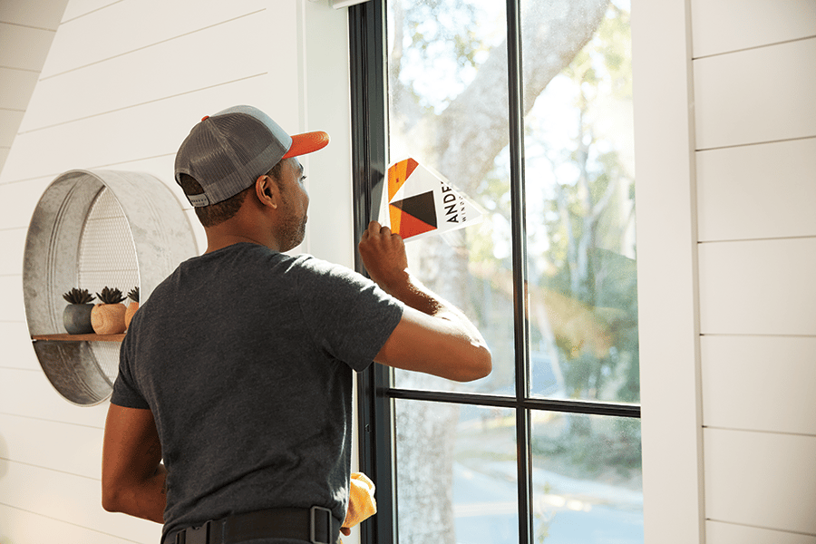 image of contractor removing andersen sticker from window